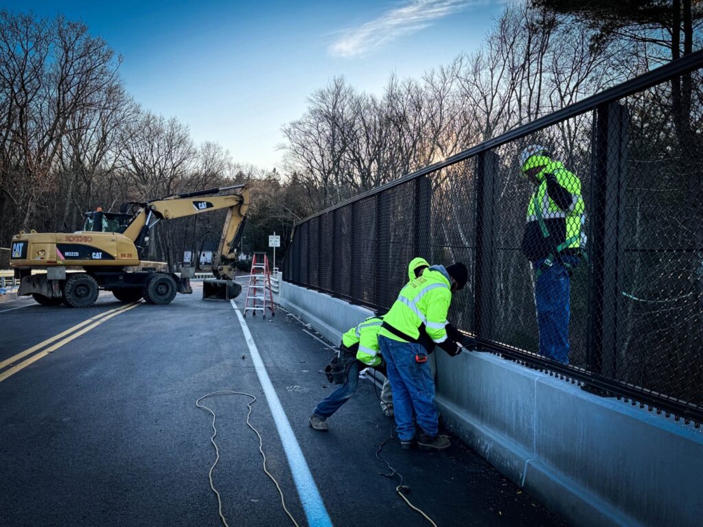 Workers installing the last of the trim on the Fruit Street MBTA bridge.