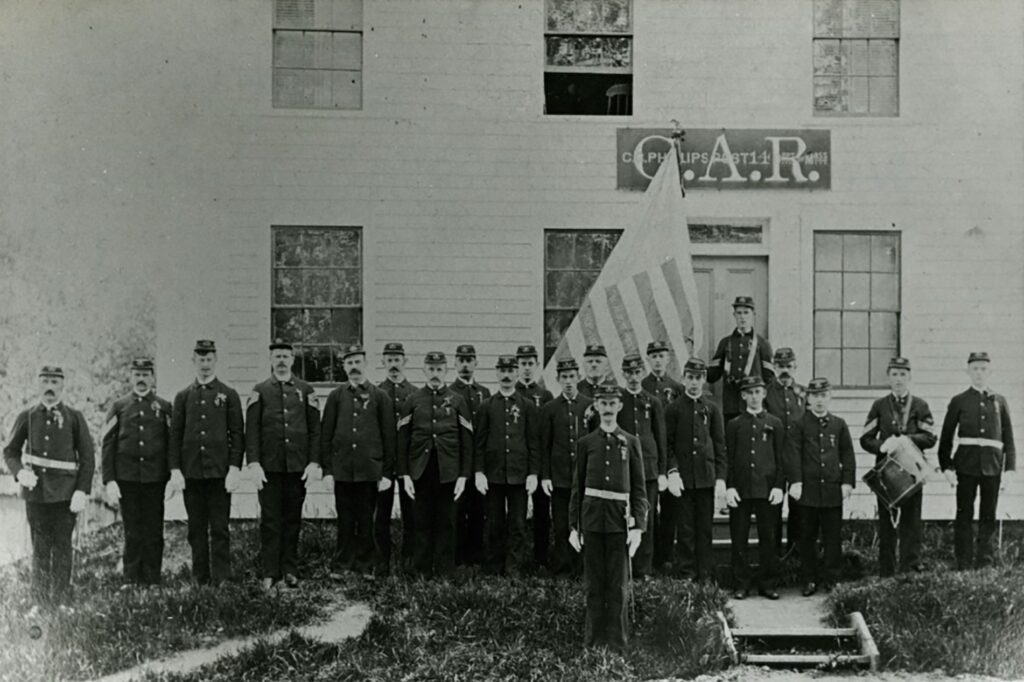 Sons of Union Veterans standing in front of the GAR building on Church Street in Hopkinton.