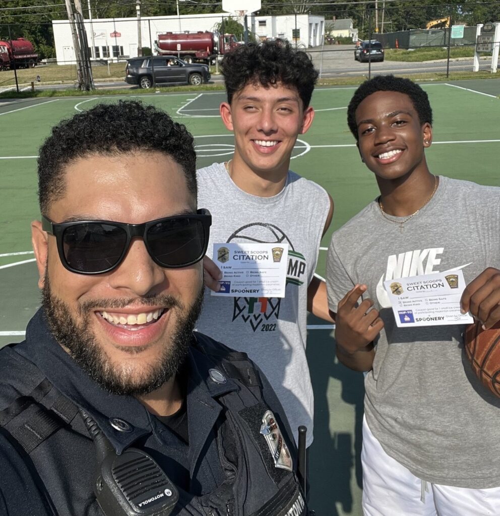 Hopkinton Police Officer Augusto Diaz handed out the first "Sweet Scoops" Citations to local Hopkinton high schoolers playing basketball. (Photo courtesy HPD)