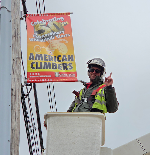 Marathon Banner and man in buket hanging it on the telephone pole