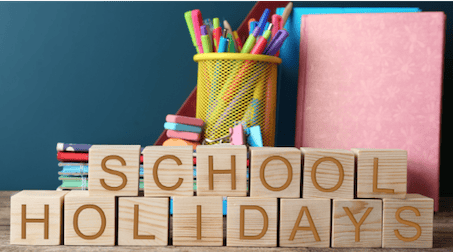 A cup of pencils and wooden blocks with the words: School Holiday.