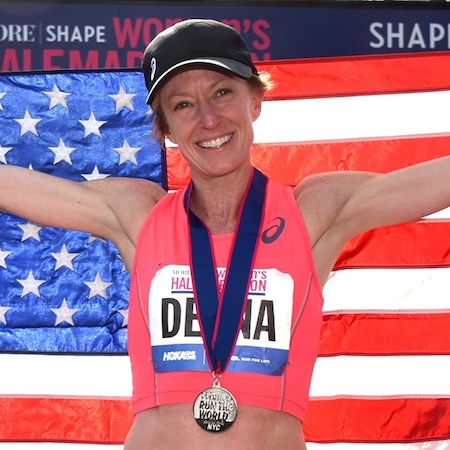 Female runner wearing medal and holding an American flag
